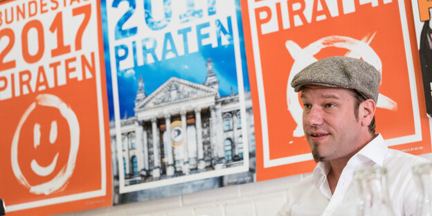 Ein Mann vor orangefarbenen Wahlplakaten Ein Mann vor orangefarbenen Wahlplakaten