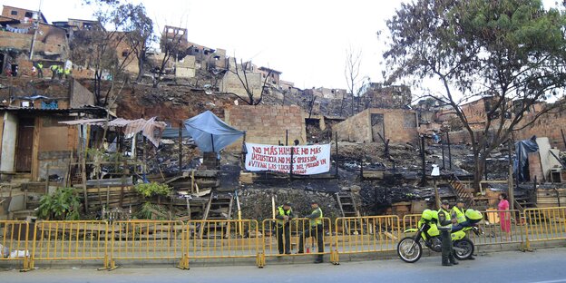 Militärpolizisten sperren den Zugang zum niedergebrannten Viertel El Oasis ab. Militärpolizisten sperren den Zugang zum niedergebrannten Viertel El Oasis ab.