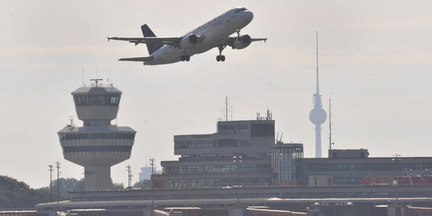 Ein Flugzeug über den Flughafengebäude von Tegel