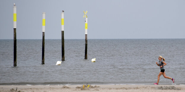 Eine Frau joggt am Strand