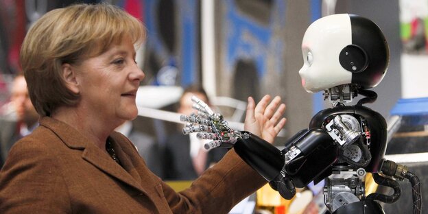 Angela Merkel und ein kinderähnlicher Roboter Angela Merkel und ein kinderähnlicher Roboter