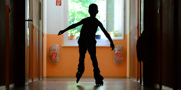 Die Silhouette eines Kindes auf einem Flur Die Silhouette eines Kindes auf einem Flur