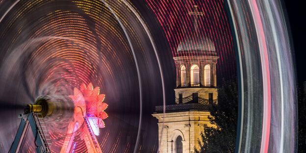 die Paulskirche bei Nacht, davor ein bunt erleuchtetes Riesenrad die Paulskirche bei Nacht, davor ein bunt erleuchtetes Riesenrad