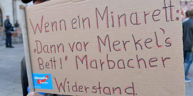 Demonstrant mit Plakat "Wenn ein Minarett, dann vor Merkels Bett" Demonstrant mit Plakat "Wenn ein Minarett, dann vor Merkels Bett"