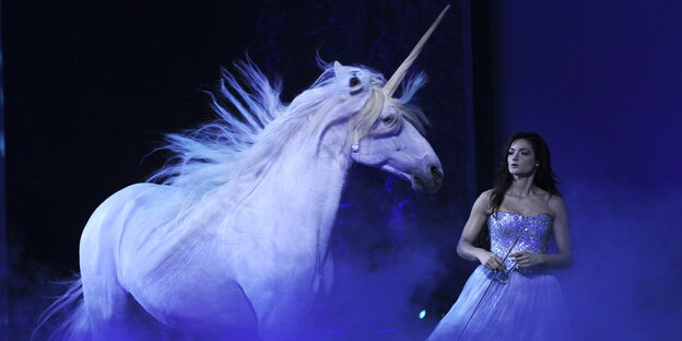 Ein Einhorn und eine Frau auf der Bühne Ein Einhorn und eine Frau auf der Bühne
