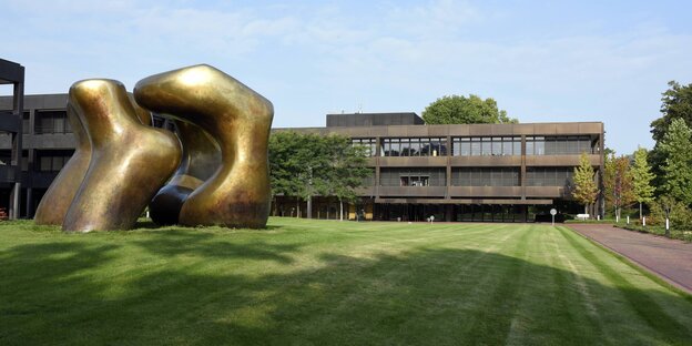 Eine Skulptur auf einer Wiese vor einem Gebäude Eine Skulptur auf einer Wiese vor einem Gebäude