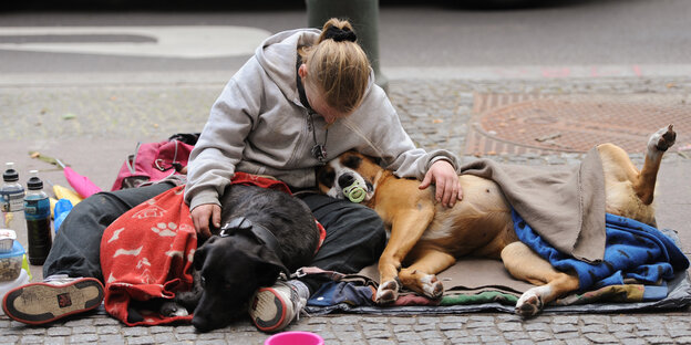Eine junge obdachlose Frau schläft auf der Straße Eine junge obdachlose Frau schläft auf der Straße