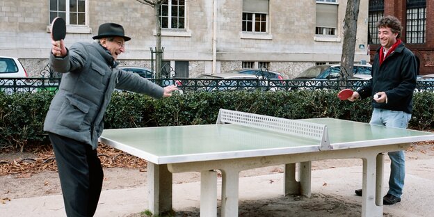 Zwei Männer spielen Tischtennis und lachen Zwei Männer spielen Tischtennis und lachen