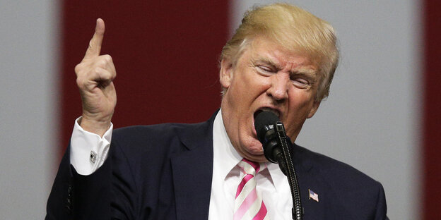 Donald Trump mit erhobenem Zeigefinger steht am Mirkofon Donald Trump mit erhobenem Zeigefinger steht am Mirkofon