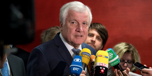 Ein Mann spricht in Pressemikrofone Ein Mann spricht in Pressemikrofone