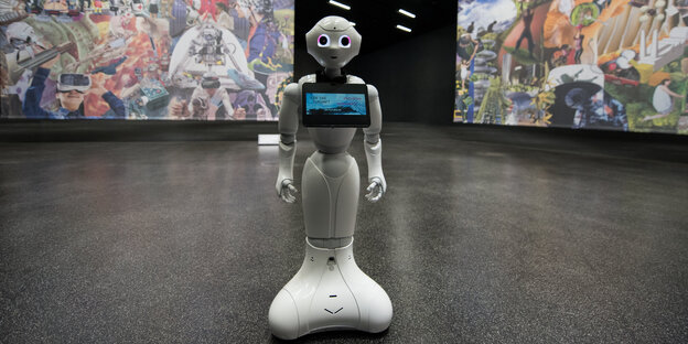Ein Roboter vor einer Wand mit Bildern Ein Roboter vor einer Wand mit Bildern