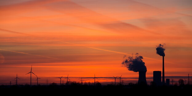 Die aufgehende Sonne taucht den Himmel hinter dem Kohlekraftwerk Mehrum in Hohenhameln in warmes Licht Die aufgehende Sonne taucht den Himmel hinter dem Kohlekraftwerk Mehrum in Hohenhameln in warmes Licht