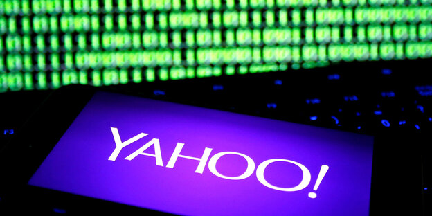 Ein Yahoo-Logo vor einer grün leuchtenden Wand Ein Yahoo-Logo vor einer grün leuchtenden Wand