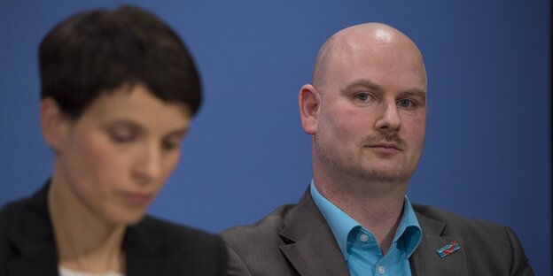 Ein Mann mit Glatze sitzt neben einer Frau mit kurzen Haaren Ein Mann mit Glatze sitzt neben einer Frau mit kurzen Haaren
