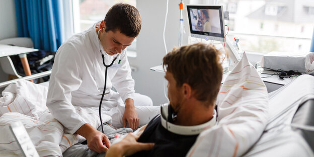 Ein junger Arzt untersucht einen Patienten Ein junger Arzt untersucht einen Patienten