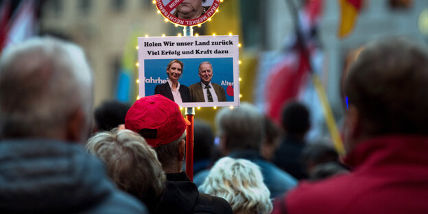 Menschen halten ein Foto der AfD-Spitzenkandidaten Alice Weidel und Alexander Gauland und die Worte Holen wir unser Land zurüc Menschen halten ein Foto der AfD-Spitzenkandidaten Alice Weidel und Alexander Gauland und die Worte Holen wir unser Land zurüc