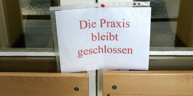 An einer Tür steht ein Schild mit der Aufschrift "Die Praxis bleibt geschlossen". An einer Tür steht ein Schild mit der Aufschrift "Die Praxis bleibt geschlossen".