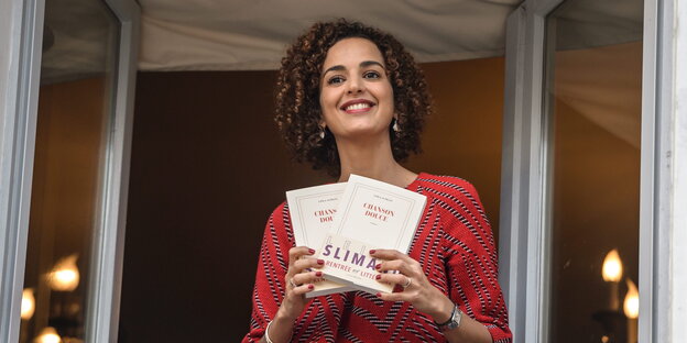 Leïla Slimani zeigt lachend ihr Buch am Fenster des Drouant Restaurants in Paris Leïla Slimani zeigt lachend ihr Buch am Fenster des Drouant Restaurants in Paris