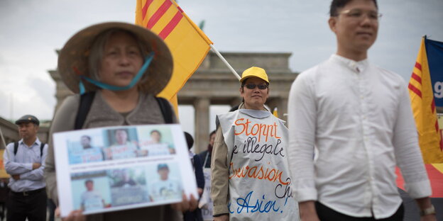 Exil-Vietnamesen mit Flaggen, Hüten und Banner vor dem Brandenburger Tor in Berlin Exil-Vietnamesen mit Flaggen, Hüten und Banner vor dem Brandenburger Tor in Berlin