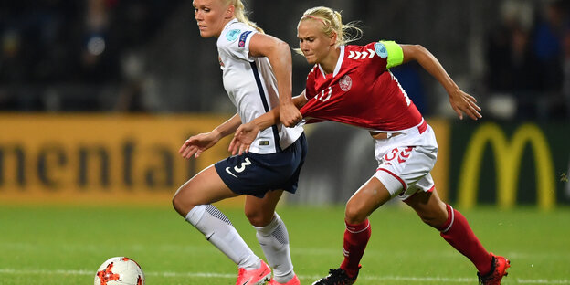 Zwei Fußballerinnen laufen einem Ball nach Zwei Fußballerinnen laufen einem Ball nach