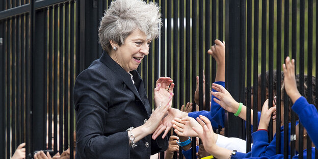 Theresa May schüttelt in einer Schule die Hände von Schülern Theresa May schüttelt in einer Schule die Hände von Schülern