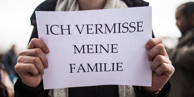 Eine Person hält ein Blatt hoch Eine Person hält ein Blatt hoch