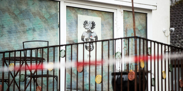 Blick auf einen Balkon mit Absperrband und einem Wappen in schwarz-weiß Blick auf einen Balkon mit Absperrband und einem Wappen in schwarz-weiß