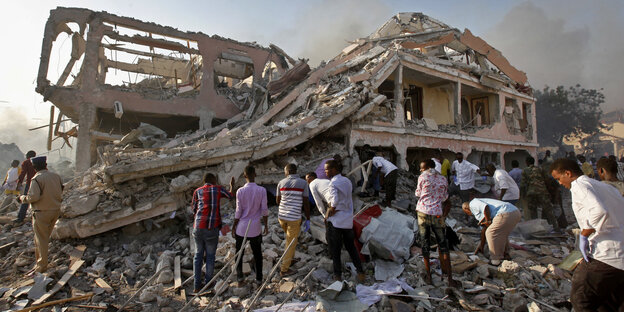 menschen sichen in Mogadischu am Anschlagsort nach Verschütteten menschen sichen in Mogadischu am Anschlagsort nach Verschütteten
