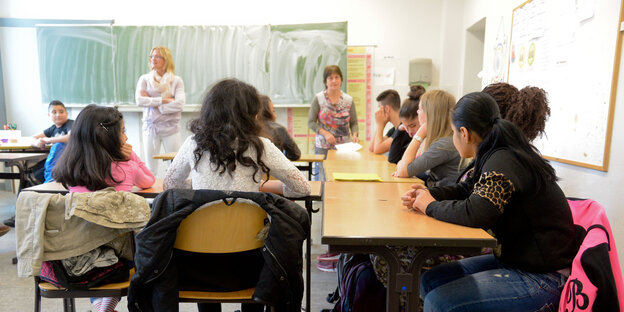 Kinder an Tischen im Klassenraum Kinder an Tischen im Klassenraum