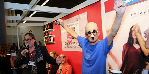 ein Mann mit lustiger Maske und erhobenen Händen ein Mann mit lustiger Maske und erhobenen Händen