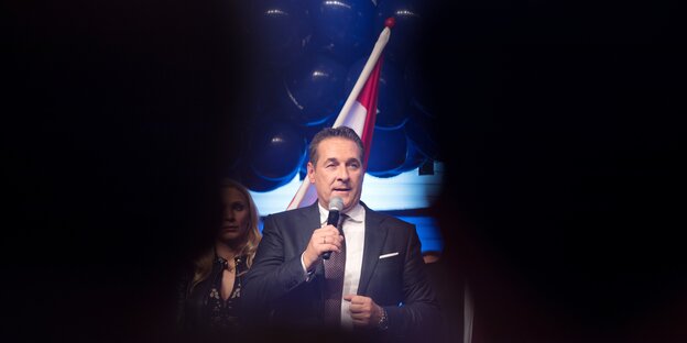 Hein-Christian Strache steht vor einer Flagge Österreichs, um ihn herum ist sonst alles schwarz Hein-Christian Strache steht vor einer Flagge Österreichs, um ihn herum ist sonst alles schwarz