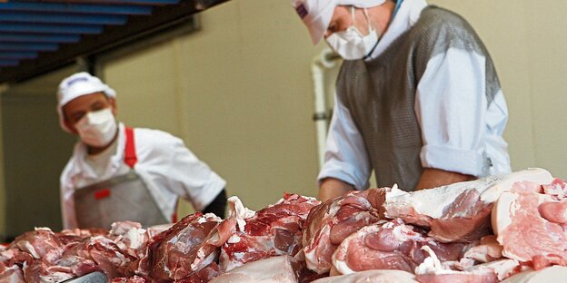 Männer, die Fleisch zerlegen Männer, die Fleisch zerlegen