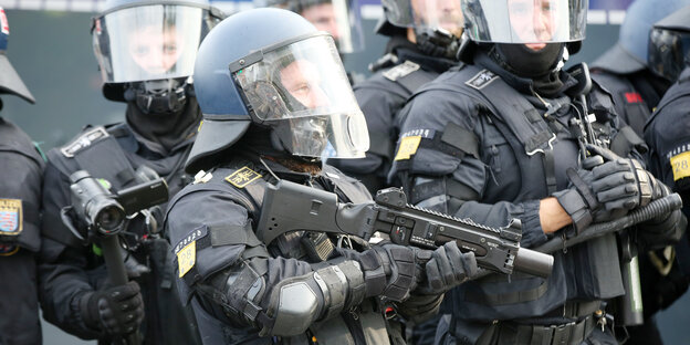 2 behelmte Polizeibeamte mit Granatpistole 2 behelmte Polizeibeamte mit Granatpistole
