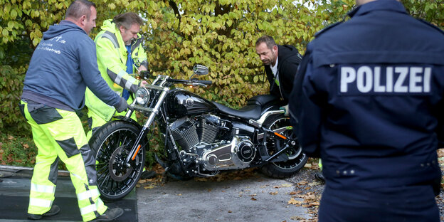 Polizisten beschlagnahmen ein Motorrad Polizisten beschlagnahmen ein Motorrad