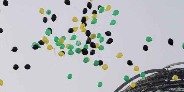 Schwarze, gelbe und grüne Lustballons fliegen über dem Reichstag Schwarze, gelbe und grüne Lustballons fliegen über dem Reichstag