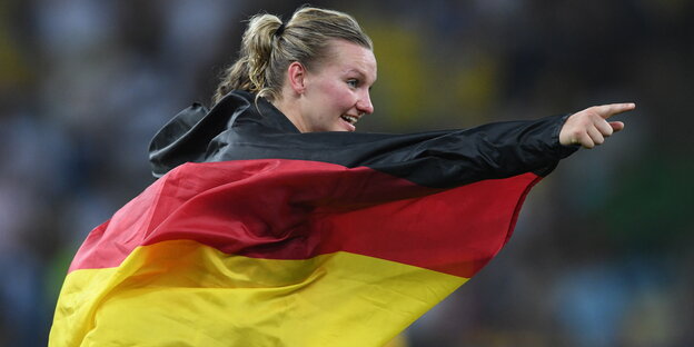 Alexandra Popp in eine schwarz-rot-goldene Fahne gehüllt Alexandra Popp in eine schwarz-rot-goldene Fahne gehüllt