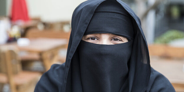 Burka tragende Frau guckt in die Kamera Burka tragende Frau guckt in die Kamera