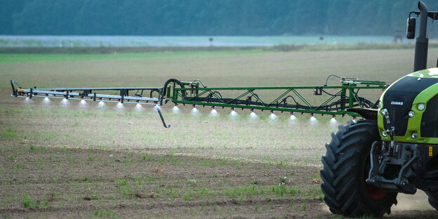 Ein Traktor sprüht Pestizid auf einen Acker Ein Traktor sprüht Pestizid auf einen Acker