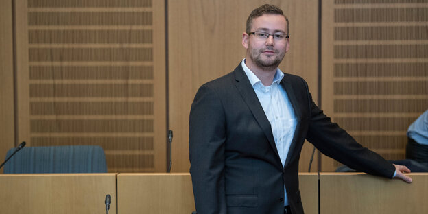 Ein Mann im Anzug in einem Gerichtssaal Ein Mann im Anzug in einem Gerichtssaal