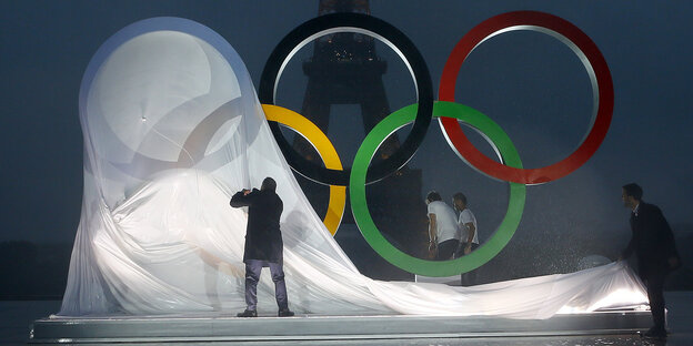 Menschen enthüllen die Olympischen Ringe Menschen enthüllen die Olympischen Ringe