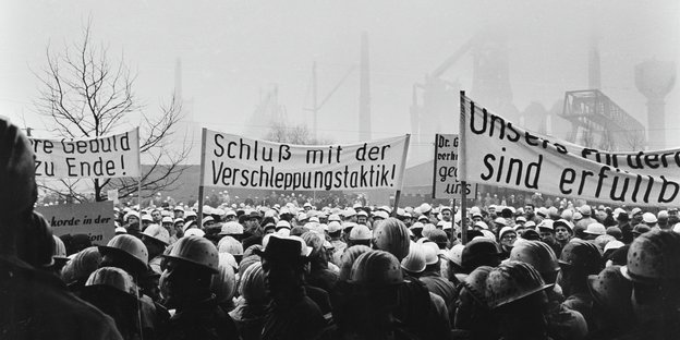 Bergarbeiter demonstrieren mit Plakaten vor einer Zeche Bergarbeiter demonstrieren mit Plakaten vor einer Zeche