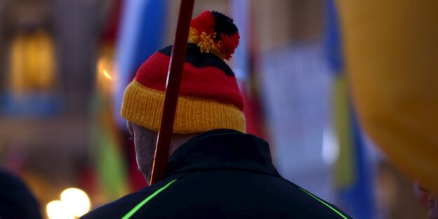 Ein Mann mit Wollmütze in den Farben der deutschen Nationalflagge. Ein Mann mit Wollmütze in den Farben der deutschen Nationalflagge.