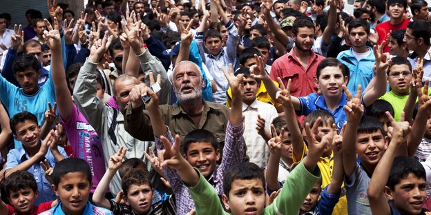 Viele Menschen halten ihre Arme nach oben Viele Menschen halten ihre Arme nach oben