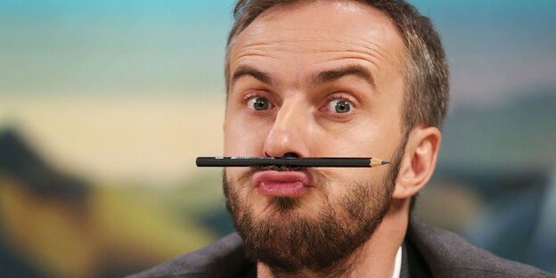 Jan Böhmermann mit einem Stift zwischen Oberlippe und Nase Jan Böhmermann mit einem Stift zwischen Oberlippe und Nase