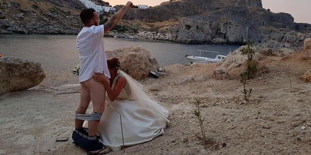 Der Bräutigam hat die Hosen runtergelassen, seine Braut kniet vor ihm und simuliert einen Blow Job, vor der malerischen Kulisse von Lindos auf Rhodos Der Bräutigam hat die Hosen runtergelassen, seine Braut kniet vor ihm und simuliert einen Blow Job, vor der malerischen Kulisse von Lindos auf Rhodos