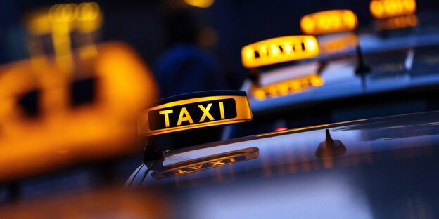 Mehrere leuchtende Taxischilder hintereinander Mehrere leuchtende Taxischilder hintereinander