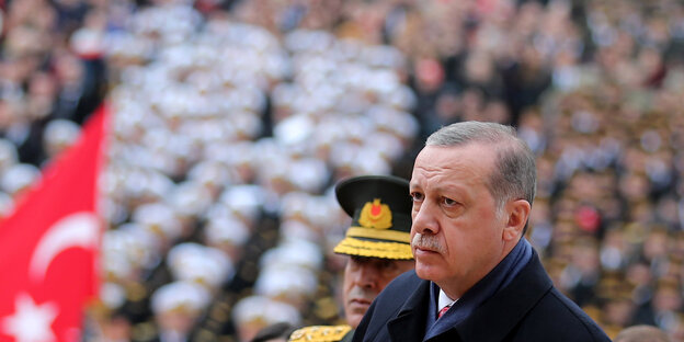 Mann neben Kranz mit der türkischen Fahne Mann neben Kranz mit der türkischen Fahne
