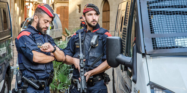 zwei Polizisten zwischen zwei Fahrzeugen zwei Polizisten zwischen zwei Fahrzeugen