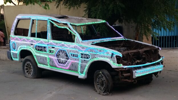 ein mit Lichterketten verziertes, fahruntüchtiges Auto ein mit Lichterketten verziertes, fahruntüchtiges Auto
