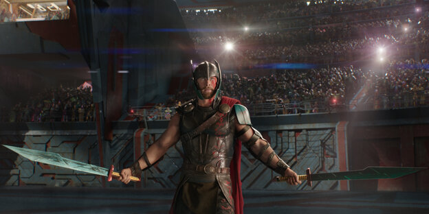 Thor steht, in jeder Hand ein Schwert, in einer Manege Thor steht, in jeder Hand ein Schwert, in einer Manege